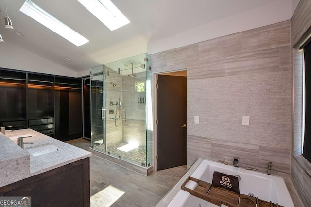 bathroom featuring lofted ceiling, shower with separate bathtub, and vanity