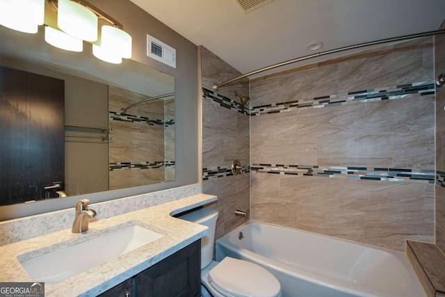 full bathroom with vanity, tiled shower / bath combo, and toilet