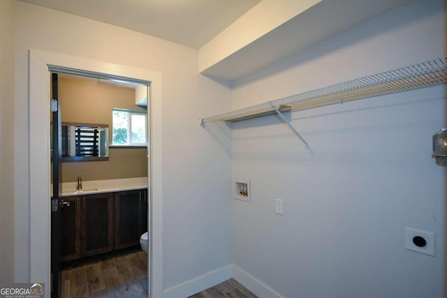 laundry room featuring electric dryer hookup, washer hookup, sink, and dark hardwood / wood-style floors