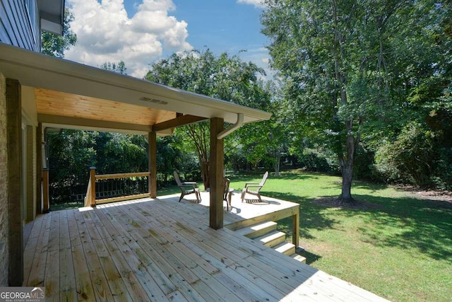 deck featuring a lawn and an outdoor fire pit