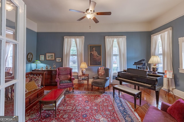 sitting room with hardwood / wood-style flooring, a wealth of natural light, and ceiling fan