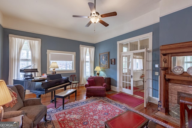 interior space with ceiling fan, wood-type flooring, and a fireplace