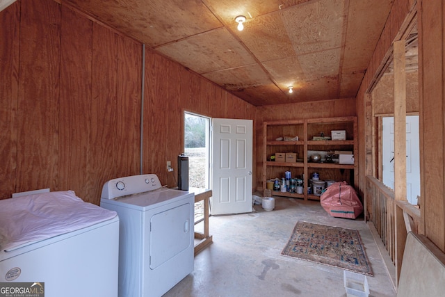 laundry area with wood ceiling, washing machine and clothes dryer, wooden walls, and built in shelves