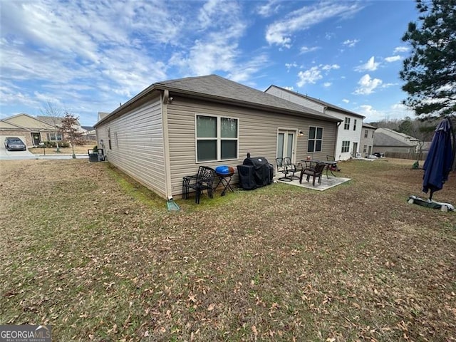 rear view of house with fence, a lawn, and a patio