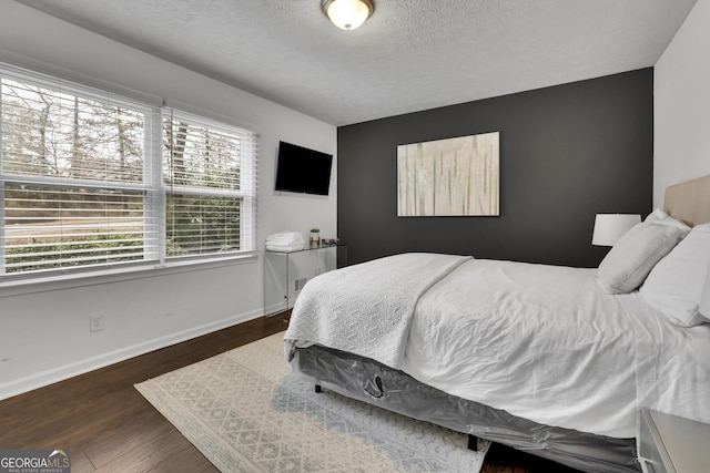 bedroom with dark wood-type flooring and a textured ceiling