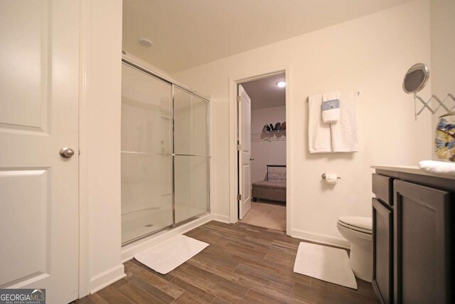 bathroom featuring vanity, hardwood / wood-style flooring, and a shower with door