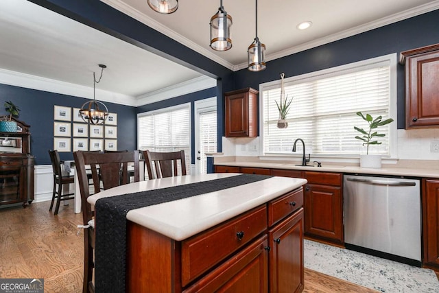 kitchen with hanging light fixtures, crown molding, light hardwood / wood-style floors, and dishwasher