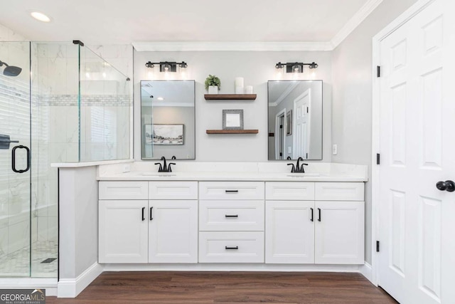 bathroom with vanity, hardwood / wood-style flooring, a shower with shower door, and ornamental molding