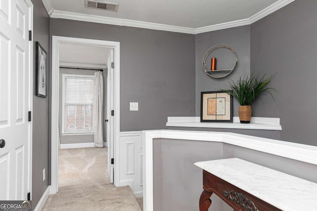 hall with crown molding and light colored carpet