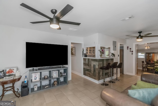 living room with ceiling fan and indoor bar