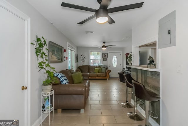 tiled living room with electric panel and ceiling fan