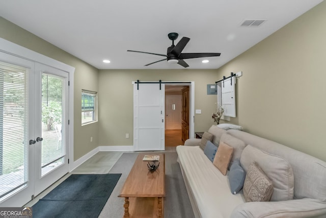 living room featuring ceiling fan and a barn door