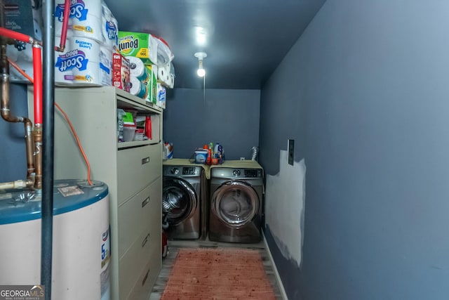 washroom with washing machine and dryer and water heater