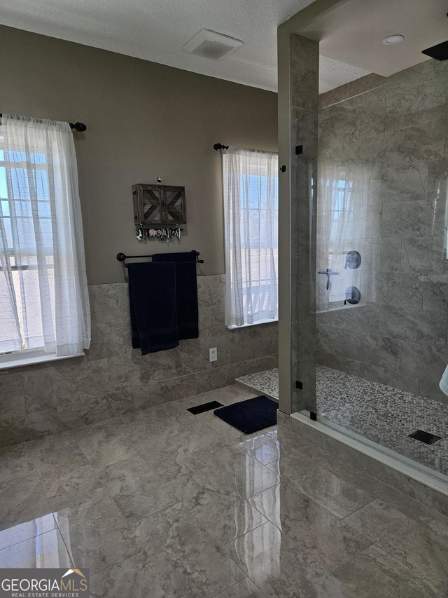 bathroom with tile walls and a tile shower