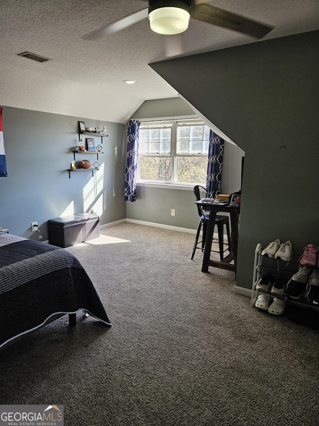 carpeted bedroom with vaulted ceiling, ceiling fan, and a textured ceiling