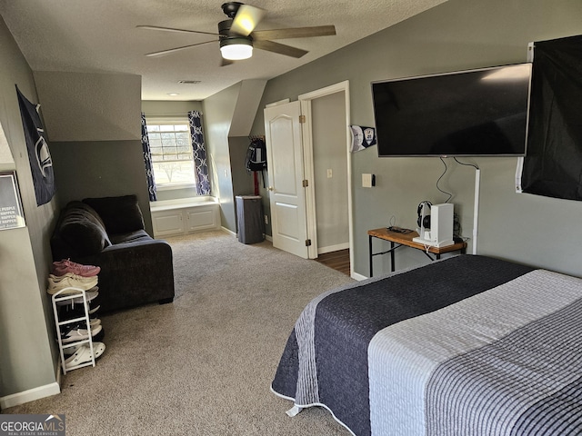 carpeted bedroom featuring ceiling fan and a textured ceiling