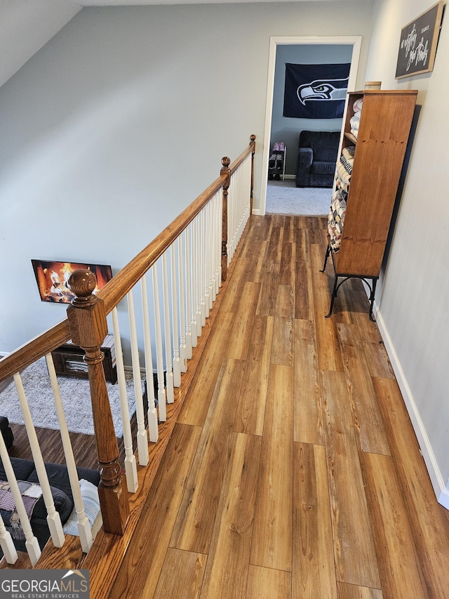 corridor featuring lofted ceiling and hardwood / wood-style flooring