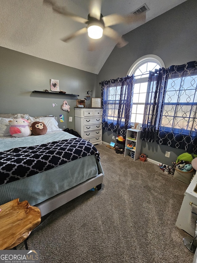 carpeted bedroom with ceiling fan, vaulted ceiling, and a textured ceiling