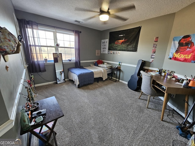 carpeted bedroom with ceiling fan and a textured ceiling