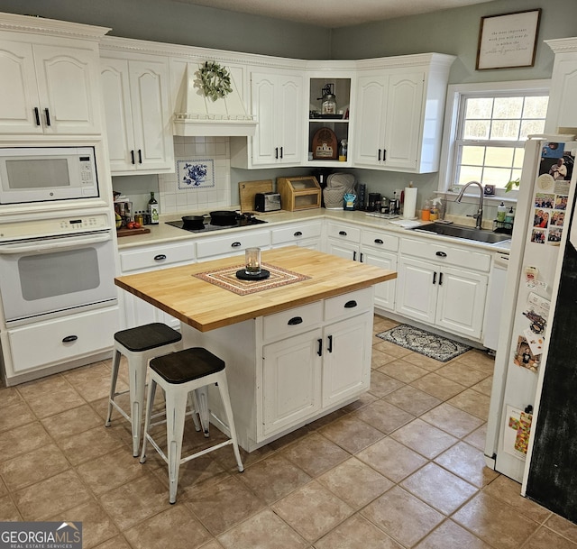 kitchen featuring sink, butcher block countertops, tasteful backsplash, white appliances, and white cabinets