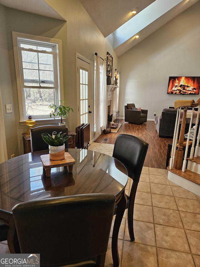 dining space featuring tile patterned flooring and vaulted ceiling