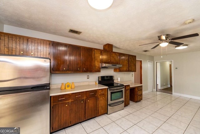 kitchen with light tile patterned flooring, ceiling fan, stainless steel appliances, and a textured ceiling