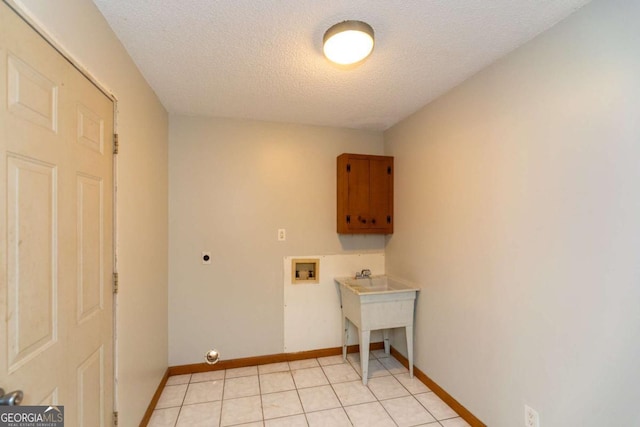 laundry room featuring light tile patterned flooring, cabinets, a textured ceiling, washer hookup, and hookup for an electric dryer