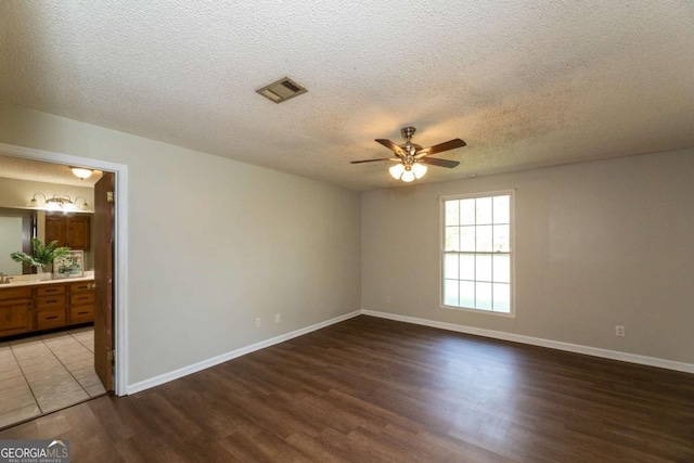 empty room with hardwood / wood-style flooring, sink, a textured ceiling, and ceiling fan