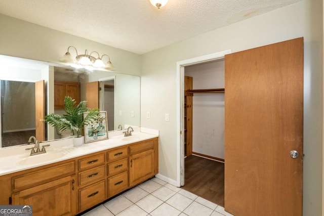 bathroom with tile patterned floors, vanity, and a textured ceiling