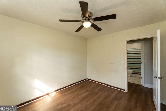 unfurnished bedroom featuring ceiling fan, dark wood-type flooring, and a textured ceiling