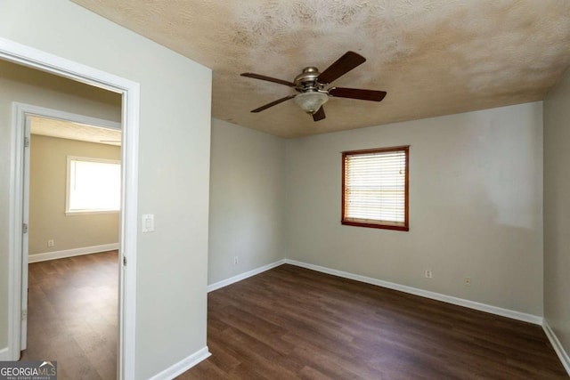 unfurnished room featuring ceiling fan, dark wood-type flooring, and a textured ceiling