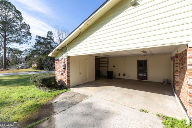 garage featuring a carport and a yard