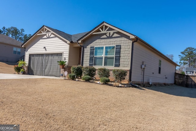 view of front of home featuring a garage, driveway, and fence