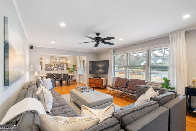 living room featuring crown molding, ceiling fan, and light hardwood / wood-style flooring