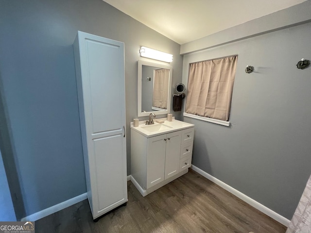 bathroom featuring vaulted ceiling, vanity, and hardwood / wood-style floors