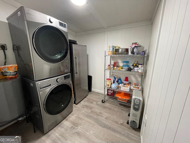 clothes washing area featuring stacked washer / drying machine and light wood-type flooring