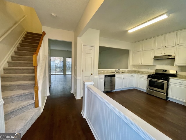 kitchen featuring sink, appliances with stainless steel finishes, a textured ceiling, white cabinets, and dark hardwood / wood-style flooring