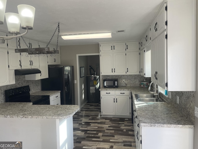 kitchen with electric water heater, tasteful backsplash, white cabinets, black appliances, and sink