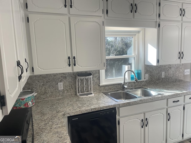 kitchen featuring white cabinets, sink, black dishwasher, and backsplash