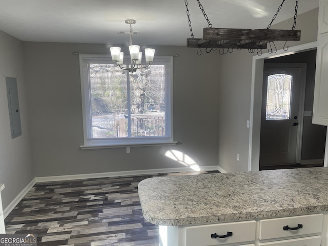 kitchen with electric panel, an inviting chandelier, white cabinetry, dark wood-type flooring, and hanging light fixtures