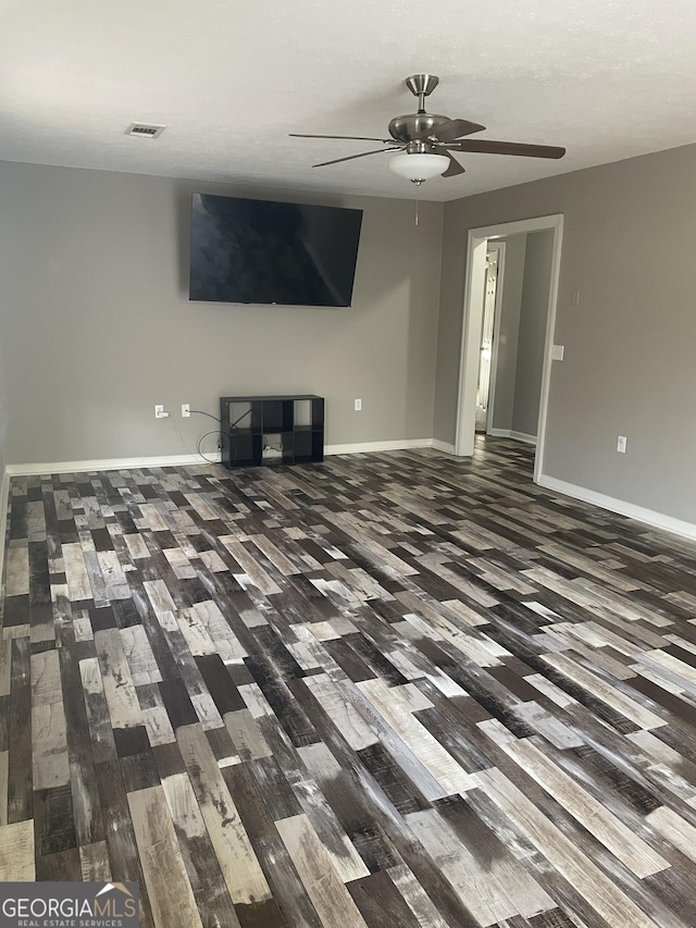 unfurnished living room with ceiling fan and dark hardwood / wood-style flooring