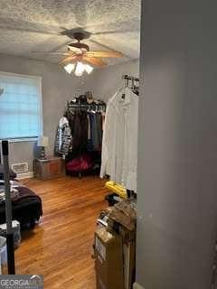 interior space with hardwood / wood-style flooring, ceiling fan, and a textured ceiling