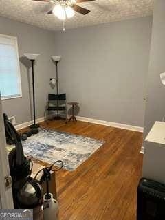 interior space featuring hardwood / wood-style flooring, ceiling fan, and a textured ceiling