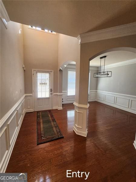 entrance foyer featuring dark hardwood / wood-style flooring and crown molding