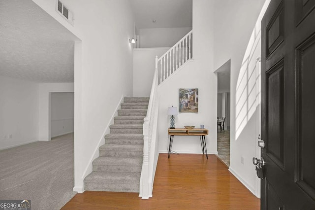 foyer entrance with light hardwood / wood-style floors and a textured ceiling