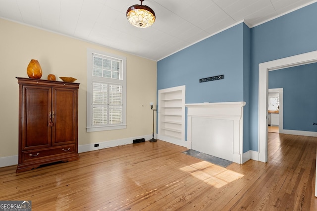 interior space featuring crown molding, built in features, and light wood-type flooring