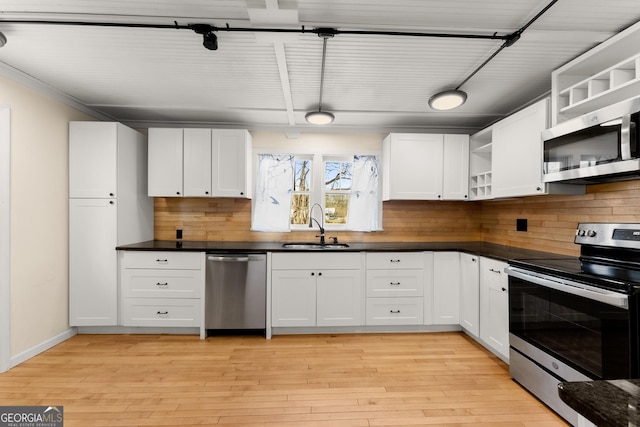 kitchen featuring stainless steel appliances, light hardwood / wood-style floors, sink, and white cabinets