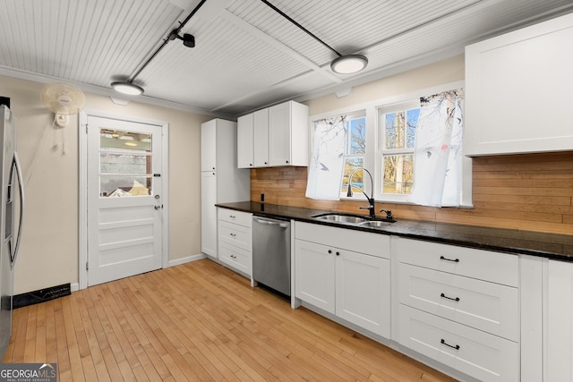 kitchen with sink, white cabinetry, dishwasher, light hardwood / wood-style floors, and decorative backsplash