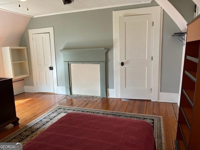 additional living space with wood-type flooring and vaulted ceiling