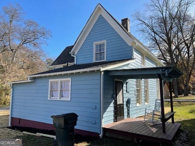 rear view of house featuring a wooden deck